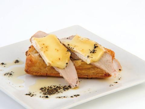 Cama de hojaldre con secreto a baja temperatura, gratinado de queso brie y aceite de oliva negra