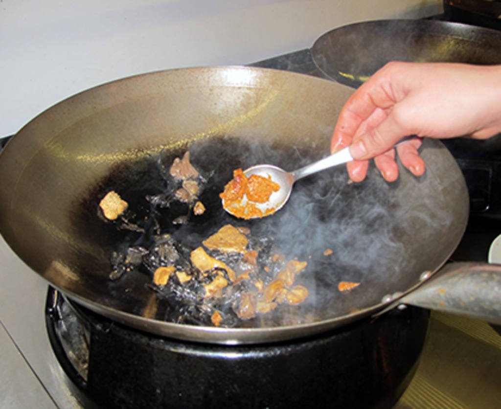 Saltear en el wok las setas y mezclarlas con una cucharada de pesto rojo.